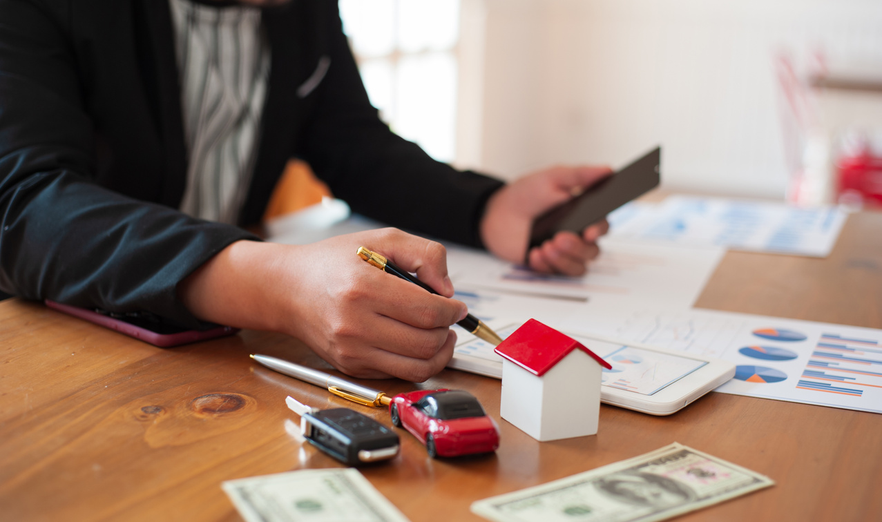 Businessman analyzes home and car lending. Personal financial planning concepts for future financial freedom.